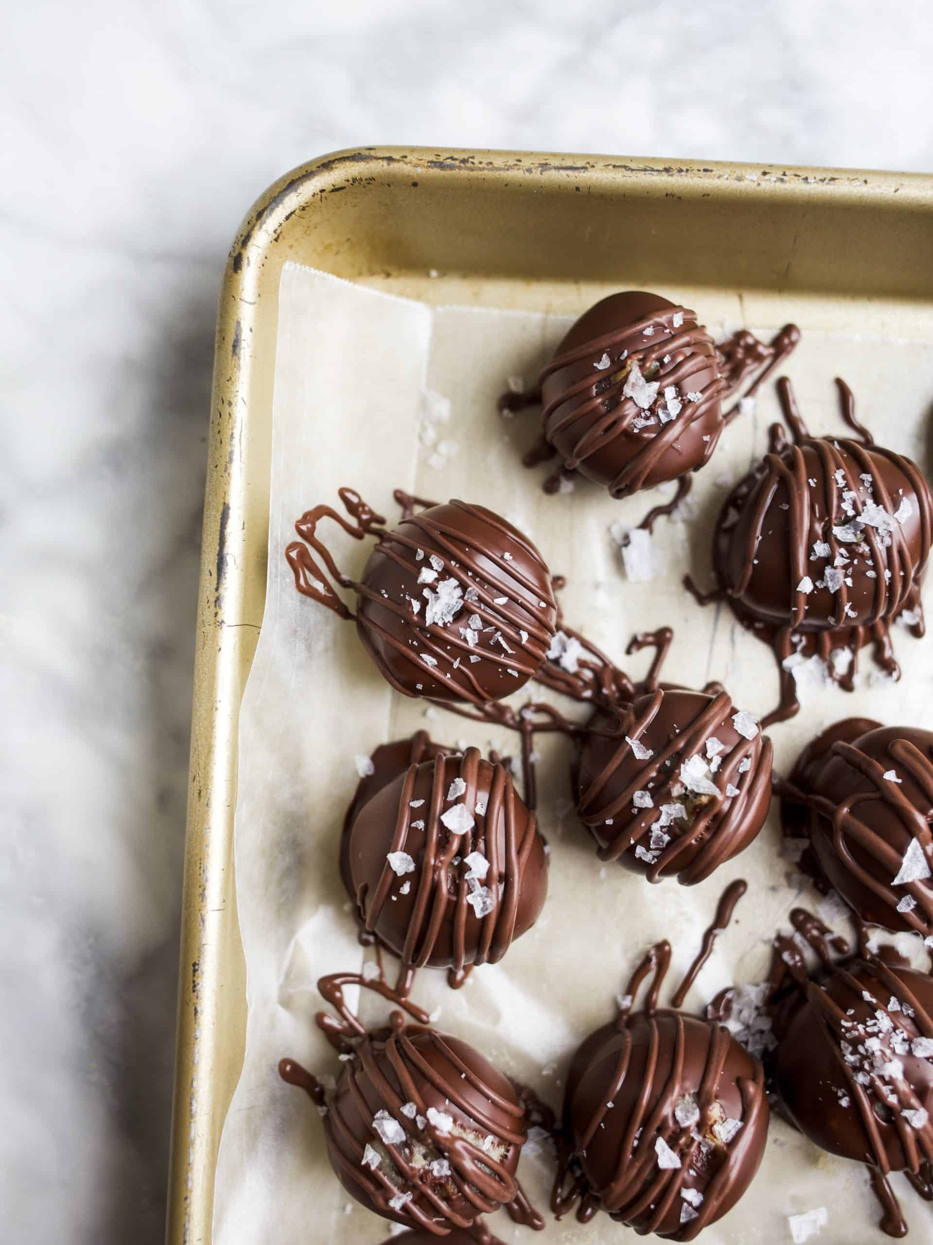 Cookie Dough Truffles by Wood and Spoon. These are eggless cookie dough balls that are dipped in melted dark chocolate and sprinkled with sea salt. The finished product are mini homemade chocolate truffles that are perfect for cookie dough lovers. Learn how simple the recipe is on thewoodandspoon.com