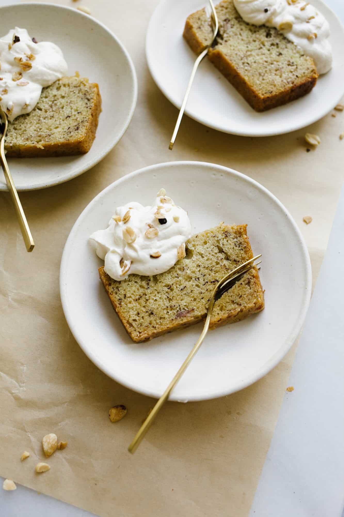 Banana Bread Cake with Peanut Butter Whipped Cream by Wood and Spoon blog. This is a moist one bowl banana bread made in a cake pan and topped with a fluffy peanut butter whipped cream. The cake can be made in a loaf or round pan and can be frozen, made ahead, and served as breakfast or dessert.