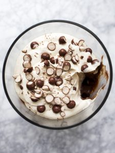 Malted Chocolate Trifle with Coffee Whipped Cream by Wood and Spoon blog. This is a simple layered brownie and chocolate pudding trifle decorated with malted chocolate balls and a coffee Kahlua whipped cream. You can simplify this recipe even more by using a boxed brownie or pudding recipe, but this homemade version of box brownies and chocolate pudding mix is so quick and easy! Learn how to make this great Easter dessert that serves a crowd on thewoodandspoon.com