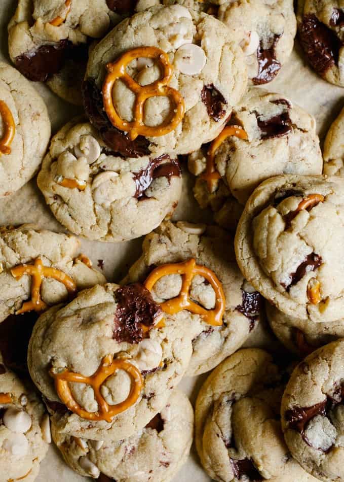 Peanut butter caramel pretzel chocolate chip cookies recipe. These are chewy peanut butter cookies with pretzel twists, chocolate chunks, and caramel bits. These are sweet and salty treats perfect for the holidays, Christmas, Thanksgiving, or cookie exchanges. Find the giant chewy gooey cookies on thewoodandspoon.com by Kate wood