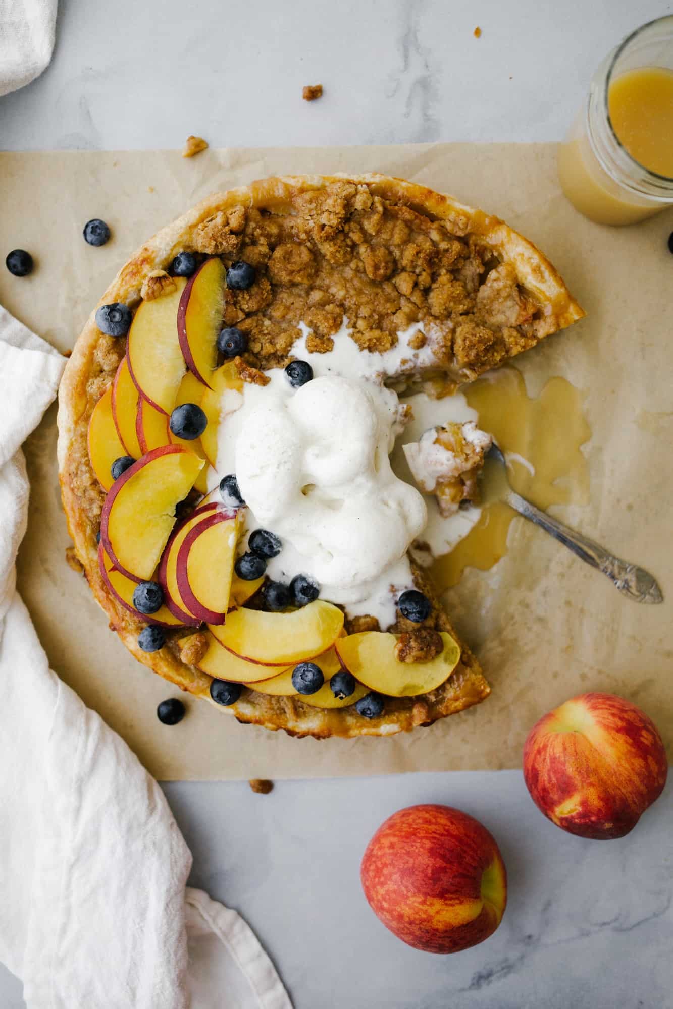 Honey Peach Pie by Wood and Spoon. This is an all butter pie crust filled with a honey caramel and fresh peaches and topped with a brown butter crumble. This pie bakes up scented with honey and juicy peaches and the crust and crumble add a bit of salt to offset the sweet. This is a great summer recipe to use fresh produce and make homemade pie tarts. Learn more about this dessert for a crowd at thewoodandspoon.com