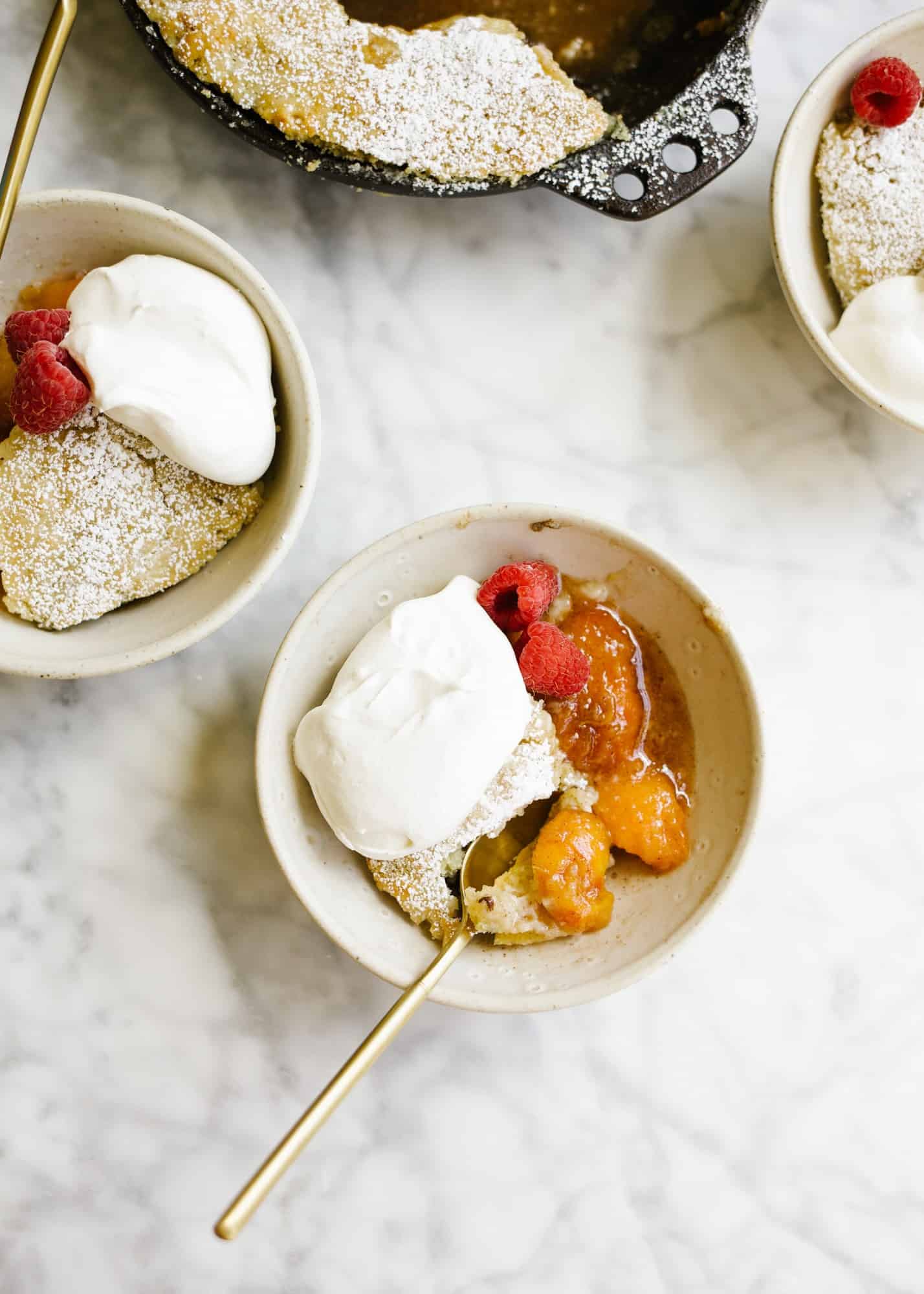 Skillet Fruit Pancake by Wood and Spoon. Similar to a breakfast cobbler, this morning treat features baked sugared fruit underneath a golden fluffy pancake. The dish serves a few and is best topped with whipped cream or a dusting of powdered sugar. Substitute in your favorite seasonal fresh or frozen fruit to enjoy! Find out more about the recipe on thewoodandspoon.com