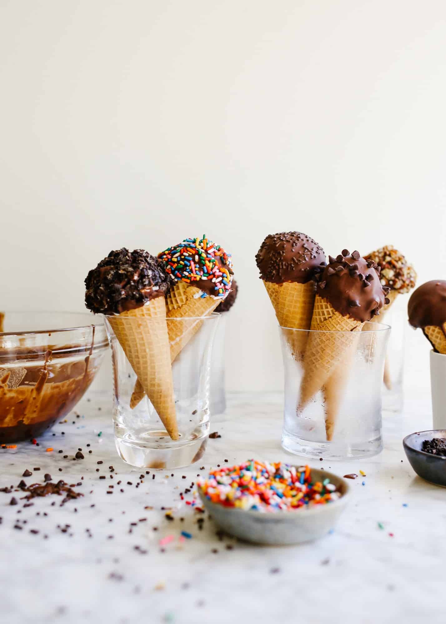 Homemade Ice Cream Drumsticks by Wood and Spoon blog. Learn how to make novelty ice cream treats with chocolate magic shell filling, ice cream scoops of choice, and a wide variety of unique toppings! The recipe is make ahead and perfect for summer treats, kids parties, and poolside desserts. Learn how to make a DIY version of these grocery store faves on thewoodandspoon.com