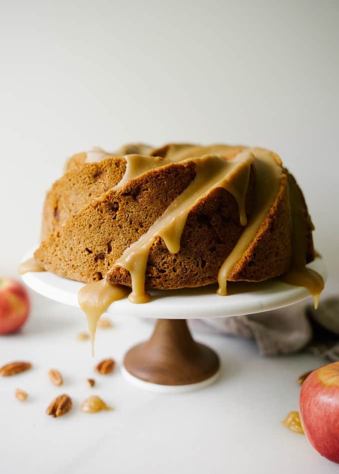 Brown Sugar Apple Bundt Cake recipe by Wood and Spoon blog. This is a fresh apple bundt cake with chunks of apples and pecans and a thick, brown sugar glaze. The cake bakes tall in a bundt or fluted pan and is topped with an old fashioned almost caramel like icing. This is a great cake to serve as dessert or breakfast this fall and at upcoming holidays. Find the recipe on thewoodandspoon.com by Kate Wood.