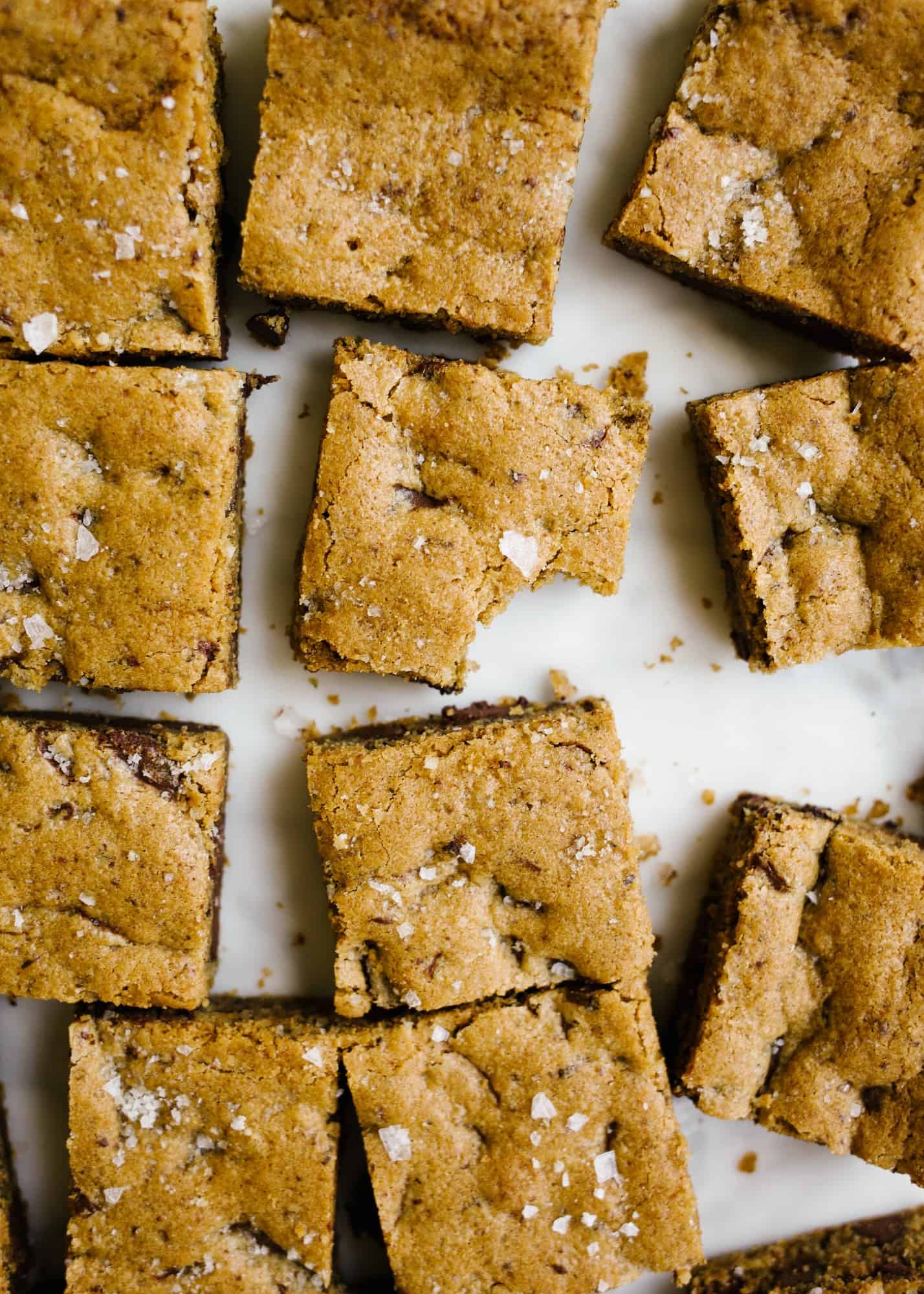 Chocolate Chip Cookie Bars by Wood and spoon. These are simple chocolate chip blondies with espresso powder and sea salt! These make rich, chewy blondie bars with crackly edges and comforting flavors. This recipe serves a crowd, freezes well, and can be made in advance! Learn how to make them on thewoodandspoon.com