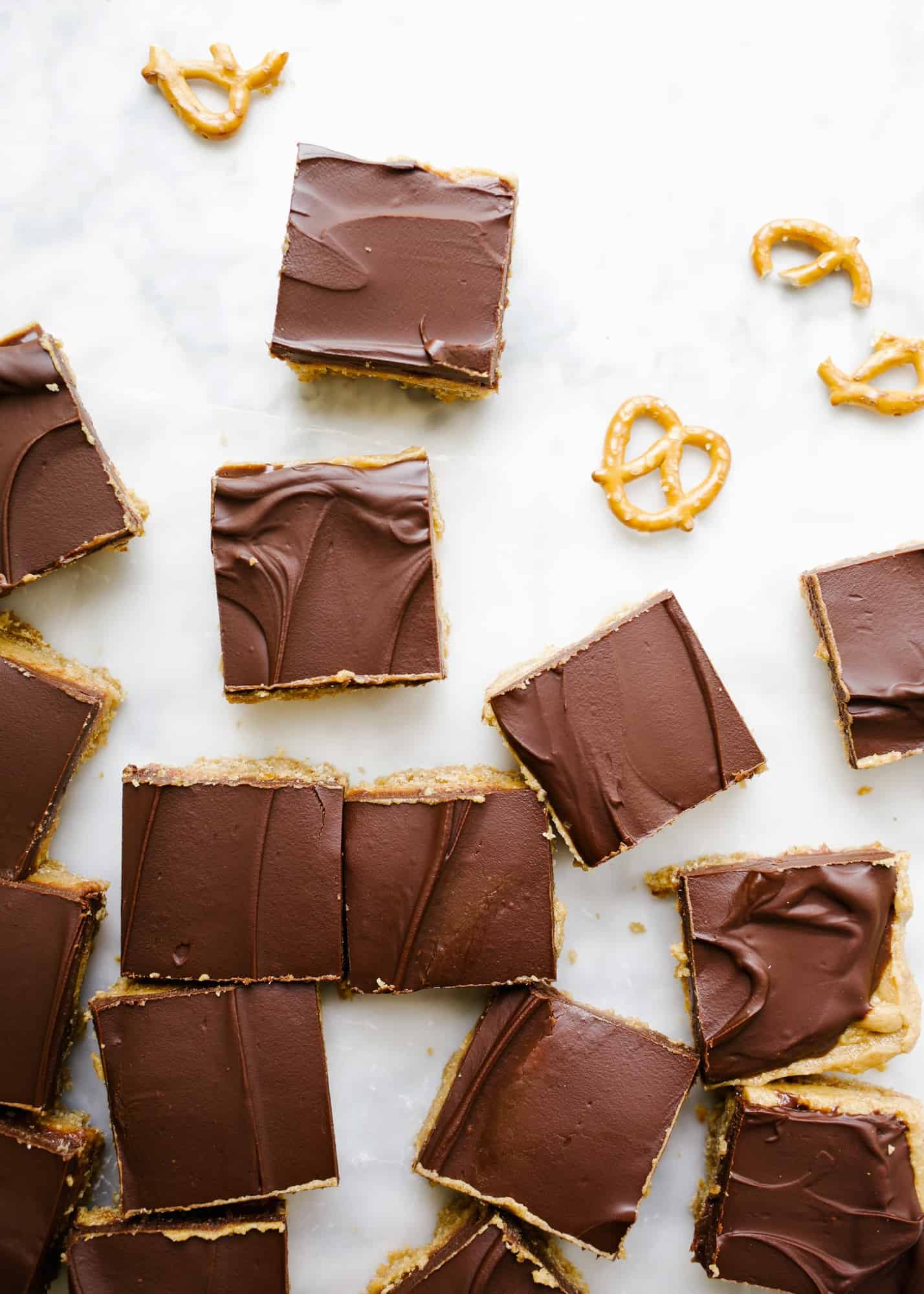 Peanut Butter Cup Bars by Wood and Spoon. These are a simple peanut butter cream stuffed square with a pretzel butter crust and a chocolate topping. These sweet treats make for an easy dessert for fall, tailgates, parties, and more, and are sure to be a favorite for peanut butter lovers. Learn how to make these simple chocolate peanut butter bars on thewoodandspoon.com