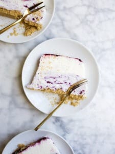 Blueberry Ice Cream Cake by Wood and Spoon blog. This is a no-churn ice cream cake recipe made with cream cheese ice cream a stovetop blueberry sauce, and a salted graham cracker crumble. This cake is a make ahead treat that is perfect for summer with fresh berries. Learn how to make homemade ice cream cake on thewoodandspoon.com