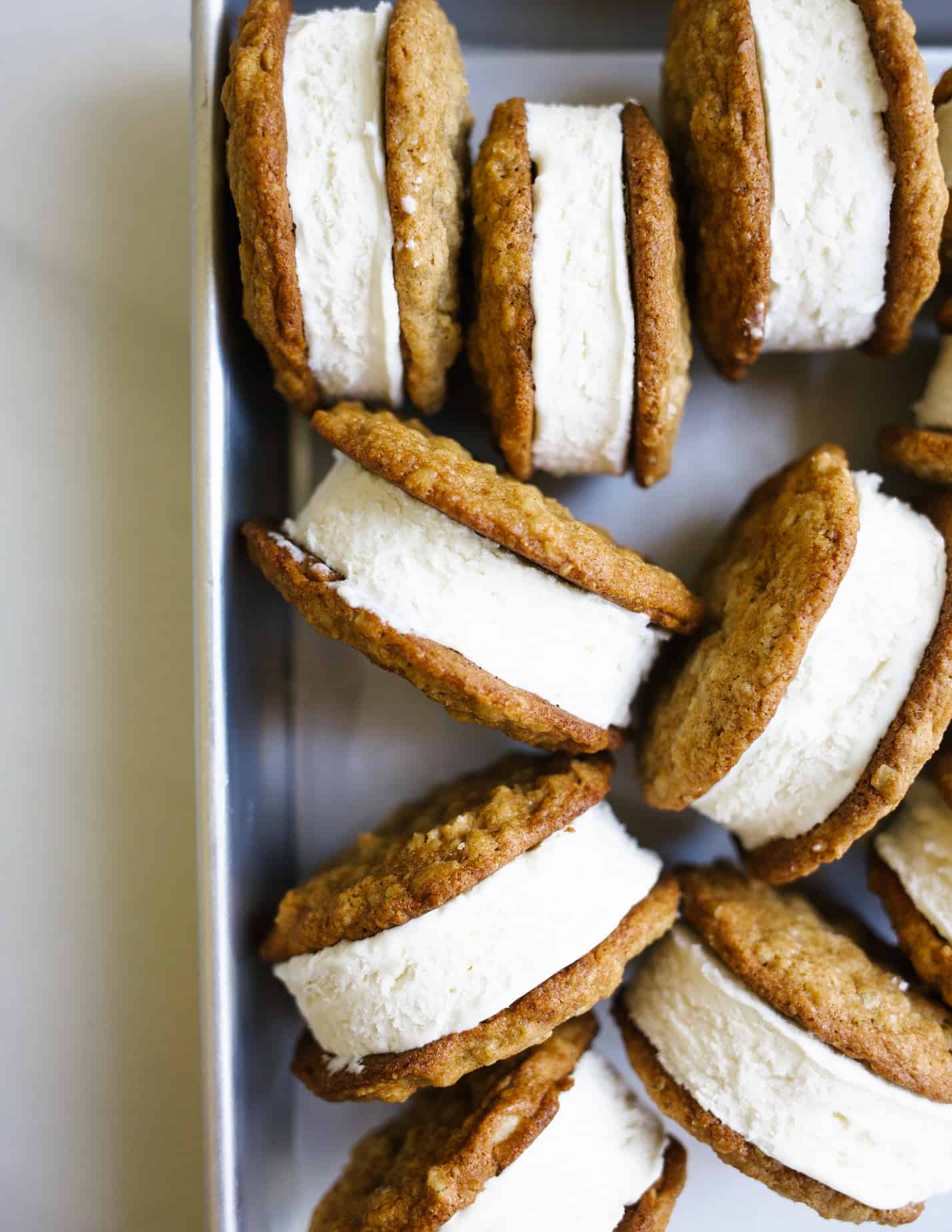 Oatmeal Cream Pie Ice Cream Sandwiches by Wood and Spoon blog. These are a frozen version of the traditional store bought cookie sandwiches made with chewy thin oatmeal cookies and filled with a no-churn marshmallow ice cream. The ice cream comes together with three ingredients including marshmallow fluff and the cookies stay soft even when frozen! Learn more about this treat and how to make homemade frozen ice cream sandwiches on thewoodandspoon.com