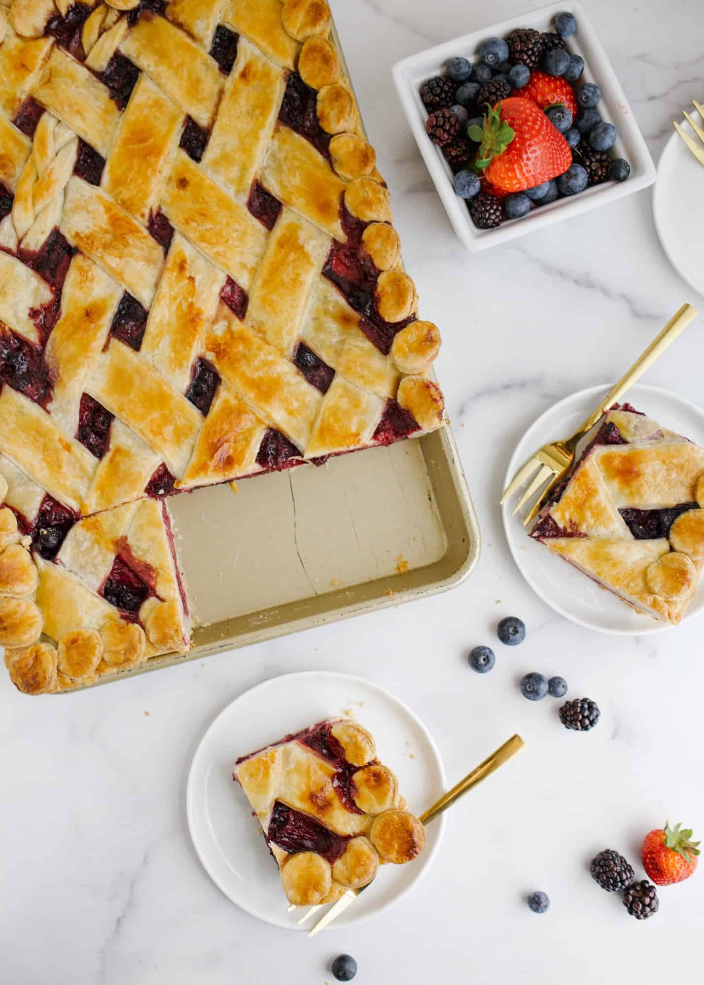 Berry Slab Pie by Wood and Spoon Blog. This is a triple berry pie with blueberries raspberries and strawberries, scented with cinnamon and layered flat in a sheet pan. This summer pie serves a crowd and has an all-butter pie crust. This make ahead dessert is great for outdoor parties and picnics. Learn how to make this lattice on thewoodandspoon.com