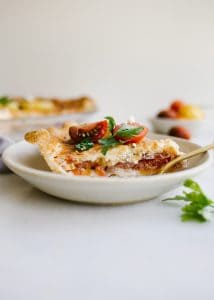 Tomato Pie by Wood and Spoon. This is a simple summer pie of fresh farm tomatoes, cheddar cheese, Italian herbs, and a buttery flaky crust! Learn how simple it is to make this savory pie that makes for a terrific lunch or dinner option! Serve this pie for summer gatherings! Learn more on thewoodandspoon.com