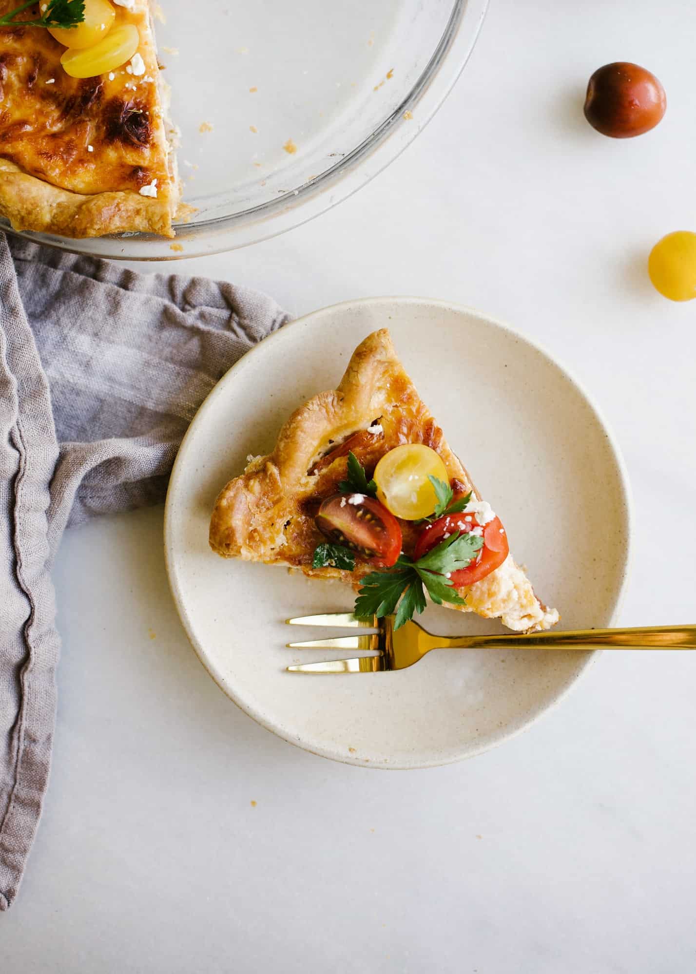 Tomato Pie by Wood and Spoon. This is a simple summer pie of fresh farm tomatoes, cheddar cheese, Italian herbs, and a buttery flaky crust! Learn how simple it is to make this savory pie that makes for a terrific lunch or dinner option! Serve this pie for summer gatherings! Learn more on thewoodandspoon.com