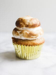 S'mores Hi-Hat Cupcakes by Wood and Spoon blog. These are graham cracker cupcakes topped with a marshmallow topping and dipped in a milk chocolate shell. These cupcakes taste like s'mores and are a beautiful way to feature chocolate magic shell. Learn how to make them on thewoodandspoon.com