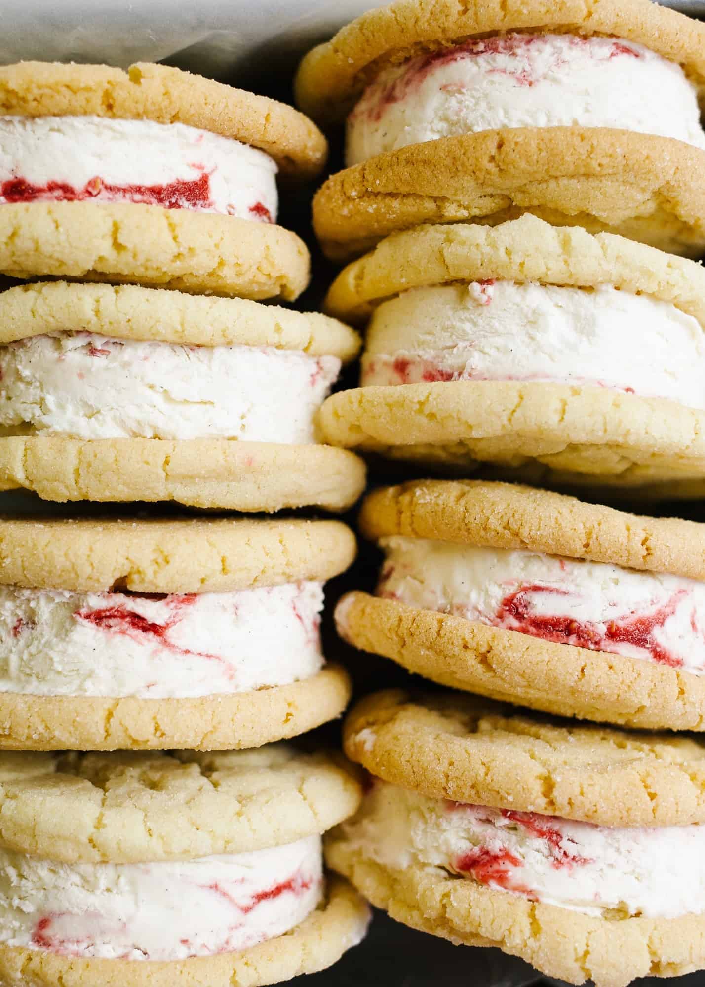 Sugar Cookie Ice Cream Sandwiches with Raspberry Ripple Ice Cream by Wood and Spoon blog. This is Sarah Keiffer's recipe for chewy sugar cookies loaded with no-sugar raspberry swirl ice cream. The ice cream is simple to put together and requires no ice cream machine. These are delicious frozen desserts! Makes enough jumbo treats to share with a crowd and is perfect for summer days! Find the recipe on thewoodandspoon.com