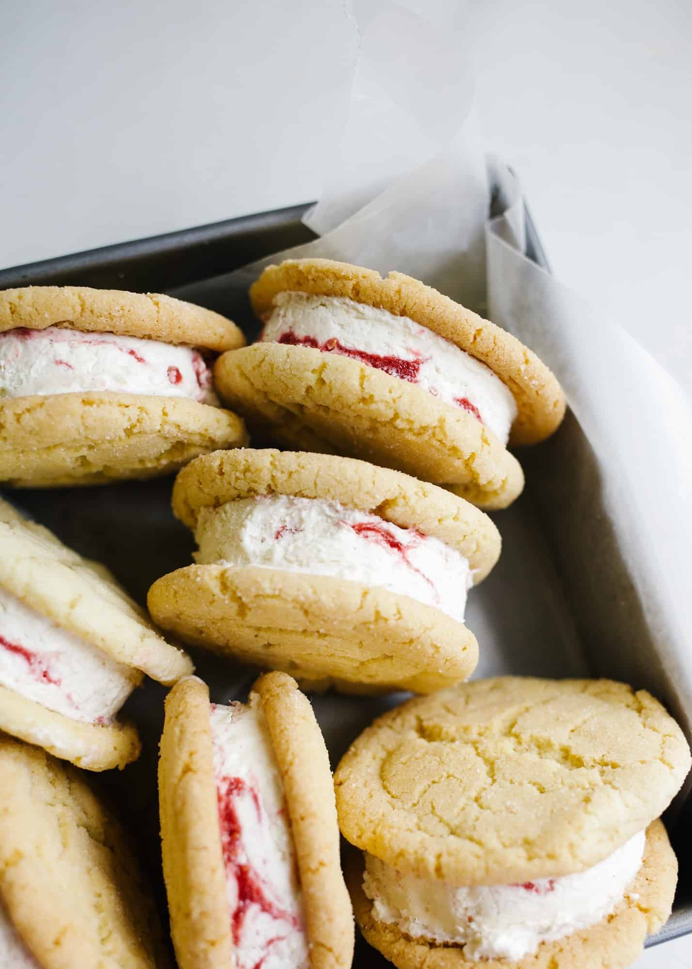 Sugar Cookie Ice Cream Sandwiches with Raspberry Ripple Ice Cream by Wood and Spoon blog. This is Sarah Keiffer's recipe for chewy sugar cookies loaded with no-sugar raspberry swirl ice cream. The ice cream is simple to put together and requires no ice cream machine. These are delicious frozen desserts! Makes enough jumbo treats to share with a crowd and is perfect for summer days! Find the recipe on thewoodandspoon.com