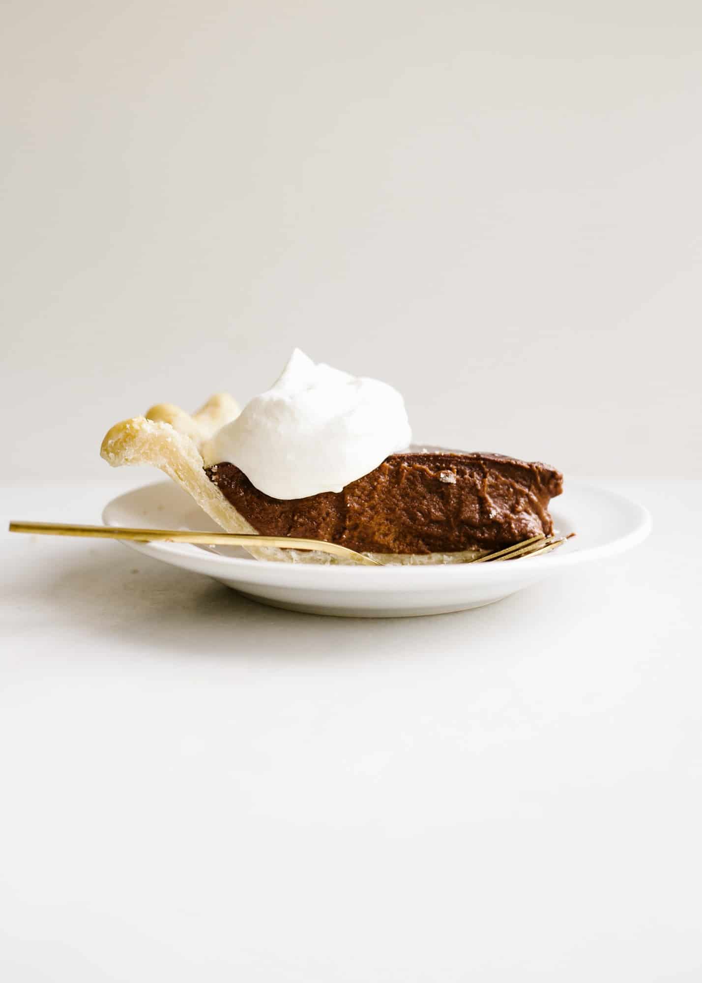 Chocolate Pudding Pie by Wood and Spoon blog. This is an old fashioned Southern chocolate cream pie with a flaky butter and shortening homemade pie crust and an egg custard filling made with cocoa powder! This is a stovetop pie that is a simple treat for a crowd all year round. Chocolate lovers will enjoy this rich dessert on thewoodandspoon.com