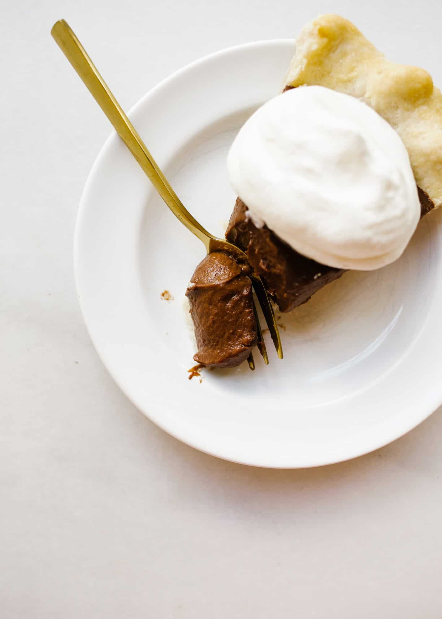 Chocolate Pudding Pie by Wood and Spoon blog. This is an old fashioned Southern chocolate cream pie with a flaky butter and shortening homemade pie crust and an egg custard filling made with cocoa powder! This is a stovetop pie that is a simple treat for a crowd all year round. Chocolate lovers will enjoy this rich dessert on thewoodandspoon.com