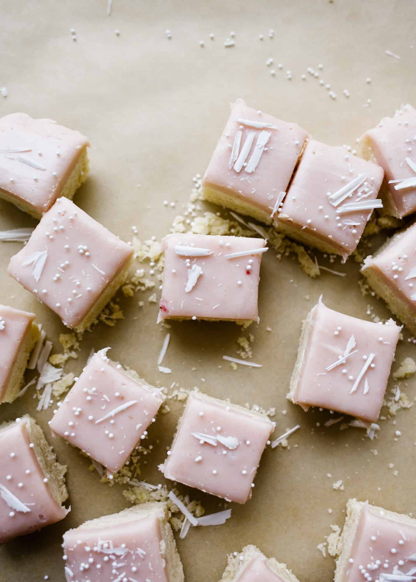 White Chocolate Ganache Shortbread by Wood and Spoon blog. These are soft and tender shortbread squares with a strawberry white chocolate ganache on top. The crust is scented with lemon zest and the topping is made with fresh strawberry puree. Learn more how to make this recipe your own with citrus zest lime zest, blueberries, raspberries and more on thewoodandspoon.com