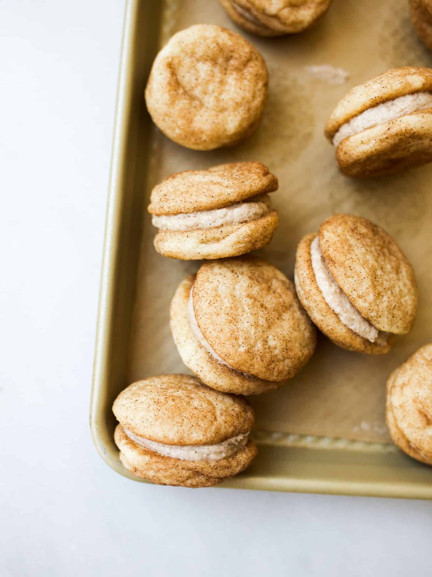 Snickerdoodle Sandwich Cookies by Wood and Spoon Blog. These are soft and chewy snickerdoodle cookies stuffed with a brown sugar cinnamon buttercream filling. These cookies are simple and made in the traditional way but with the added yum from extra filling. Learn how simple and fun this recipe is on thewoodandspoon.com- perfect for fall, holidays, and feeding a crowd!