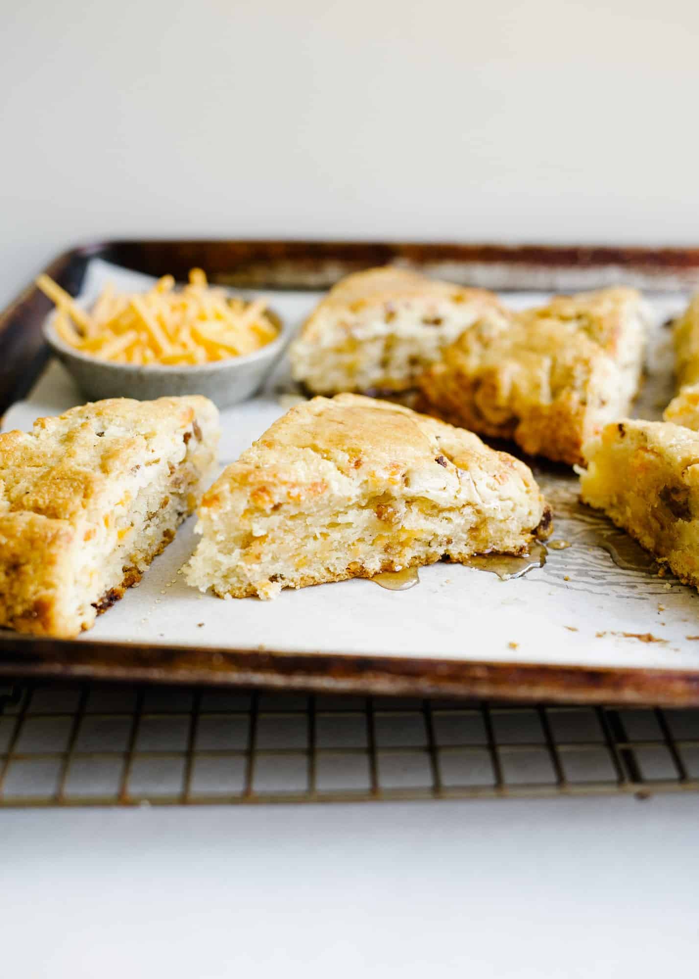 Cheddar Sausage Scones By Wood and Spoon blog. These are simple cream and butter scones sweetened with maple syrup and loaded with Italian sausage, cheddar cheese, and black pepper. These make for a delicious savory breakfast pastry or option for the meat lovers at your table. Learn how to make simple scones for brunch on thewoodandspoon.com