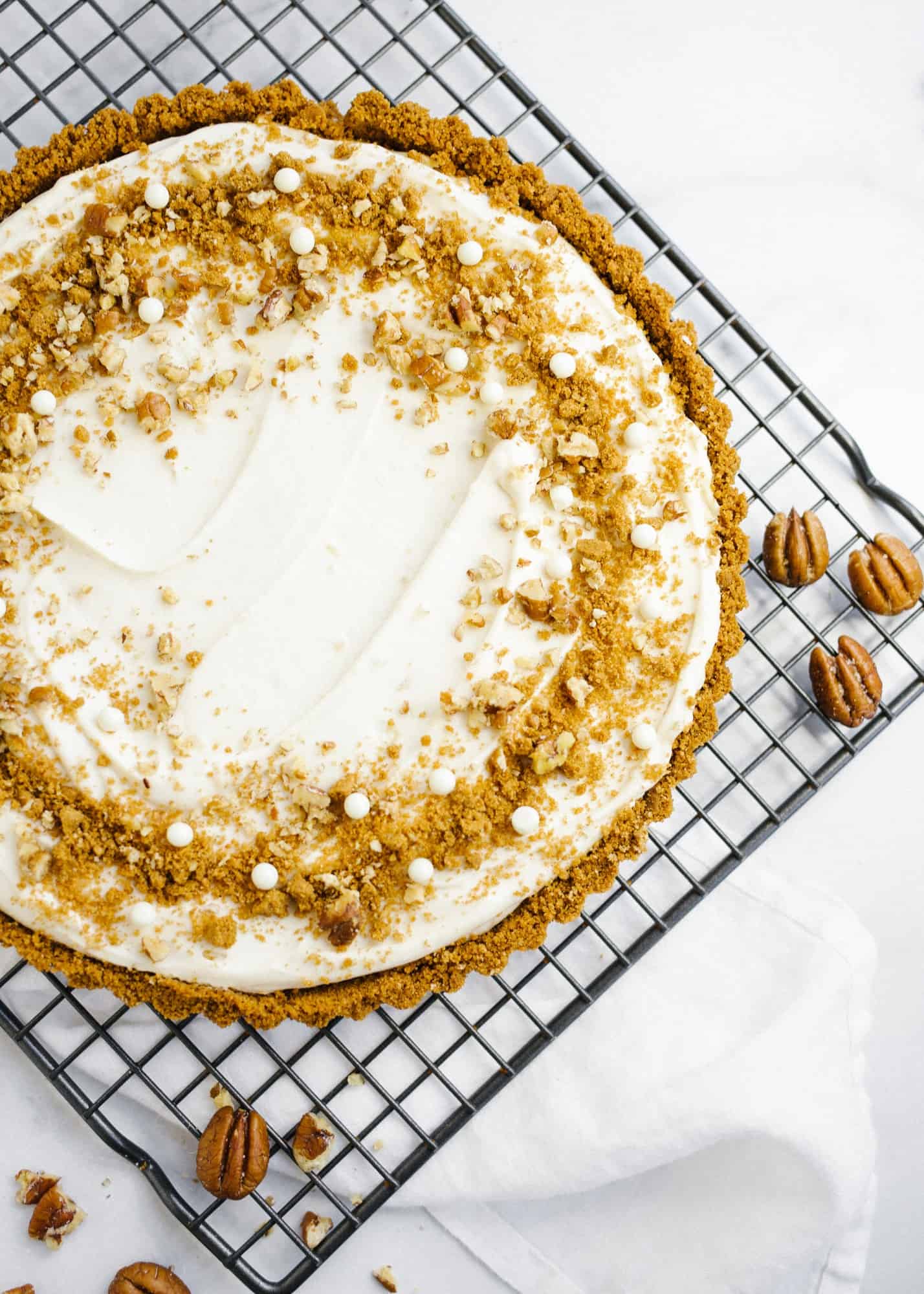 Maple Cream Tart by Wood and Spoon. This is a simple cream tart made with a biscoff cookie and pecan crust, a maple cream pie filling, and a homemade maple caramel. This sweet and salty holiday dessert can be made ahead and feeds a crowd. Learn how to make this beautiful fall dessert on thewoodandspoon.com