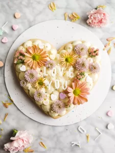 Valentine Sugar Cookie Cake by Wood and Spoon blog. This is a double layer cookie cake make with soft sugar cookie dough and a buttery filling. With a heart shape cutout, this is the perfect dessert for two (or a crowd!) to make on Valentine's Day. Check out the simple tutorial on thewoodandspoon.com