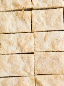 Ted Lasso Shortbread Bars by Wood and Spoon blog. These are English biscuits inspired by the hit TV show Ted Lasso. These shortbread cookie bars are made with butter, brown sugar, and powdered sugar. They require less than 10 ingredients and 5 minutes of prep time, and they are perfect for for Ted Lasso viewing party! Find the how to and recipe on thewoodandspoon.com