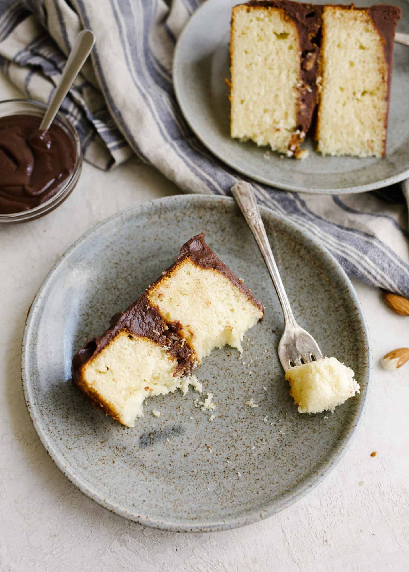 Almond Toffee Cake by Wood and Spoon. This is a vanilla layer cake with a rich chocolate fudge frosting and bits of homemade almond roca toffee throughout. The layer cake has a sweet and salty flavor and is rich with the addition of real chocolate buttercream. learn how to make this caramel tasting stacked celebration cake on thewoodandspoon.com