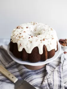 Hummingbird Bundt Cake by Wood and Spoon blog. Learn how to make this yummy textured Southern bundt cake filled with banana, coconut, pecans, and crushed pineapple! This recipe is a Southern classic and is great for th spring and easter holidays. Learn how to make it on thewoodandspoon.com