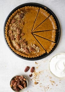 Sweet Potato Pie Tart with Candied Pecans and Marshmallow Whipped Cream by Wood and Spoon blog. A simple pumpkin pie-esque tart made with sugared nuts, a nuts and graham cracker crust, and a fluffy sweetened whipped cream topping! This is a terrific southern holiday favorite dessert to make during thanksgiving and Christmas winter months and is a beautiful take on the classic treat. Learn how to make them on thewoodandspoon.com