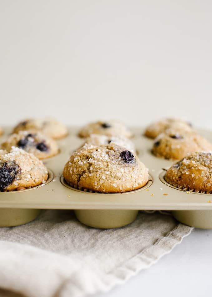 Whole Wheat Blueberry Muffins Recipe by Wood and Spoon. This is a healthy breakfast pastry featuring 100% whole wheat flour and an option for reduced sugar! The cake is sweeter extra with fresh or frozen blueberries and ends up being a fluffy treat with a big domed top. Feel good about your lighter morning foods with this baked good. Read more on thewoodandspoon.com by Kate wood