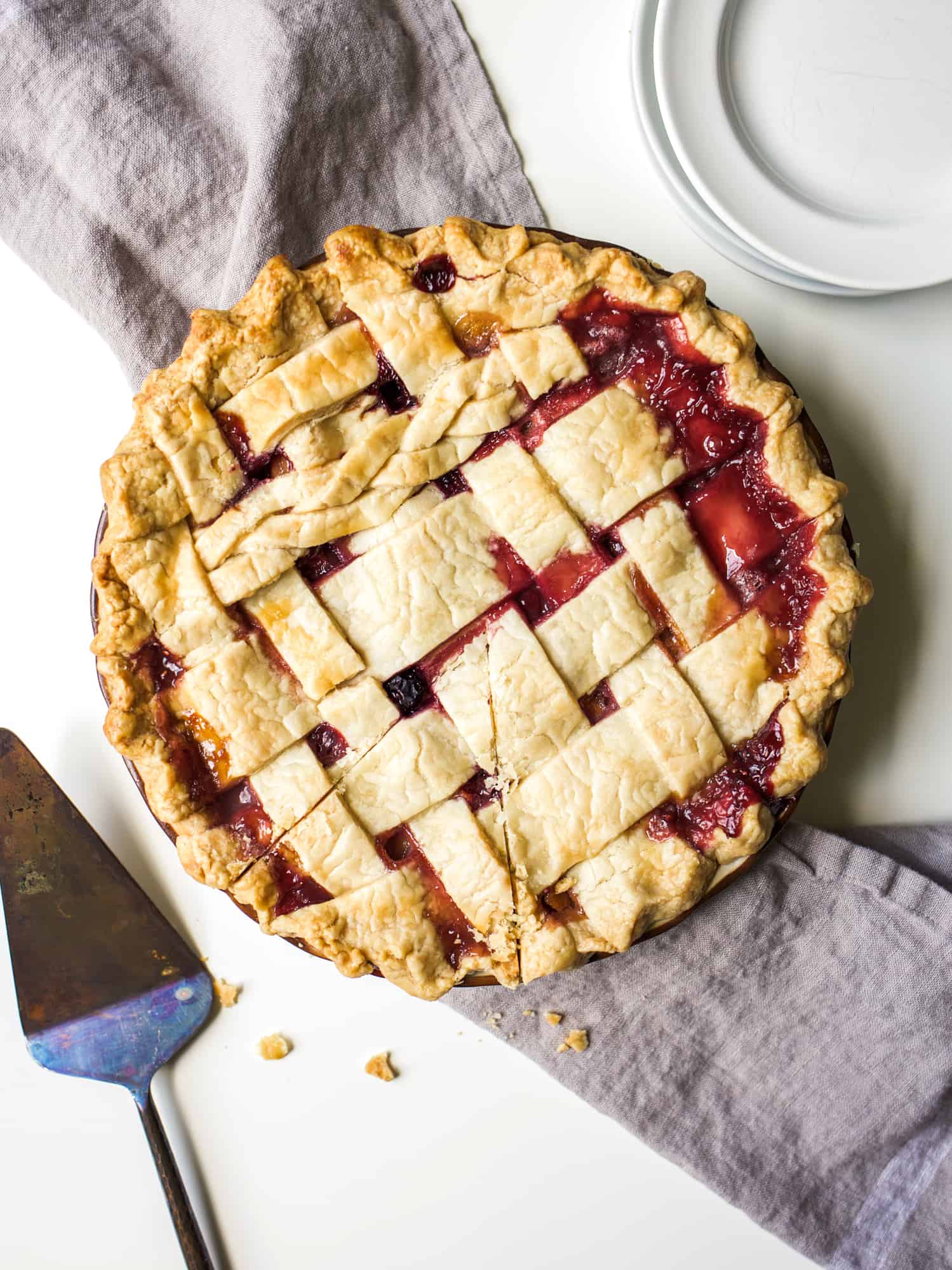 Peach Berry Pie Recipe by The Wood and Spoon Blog. A flaky, butter double crust pie dough filled with sliced peaches, straberries, raspberries, blueberries, and more. This is a perfect make ahead summer dessert and the simple instructions make this an easy pie to share with a crowd. Decorate the top of the pie with a lattice if desired. Bring this mixed berry and peach pie to your next party, BBQ, or outdoor event. woodandspoon.com