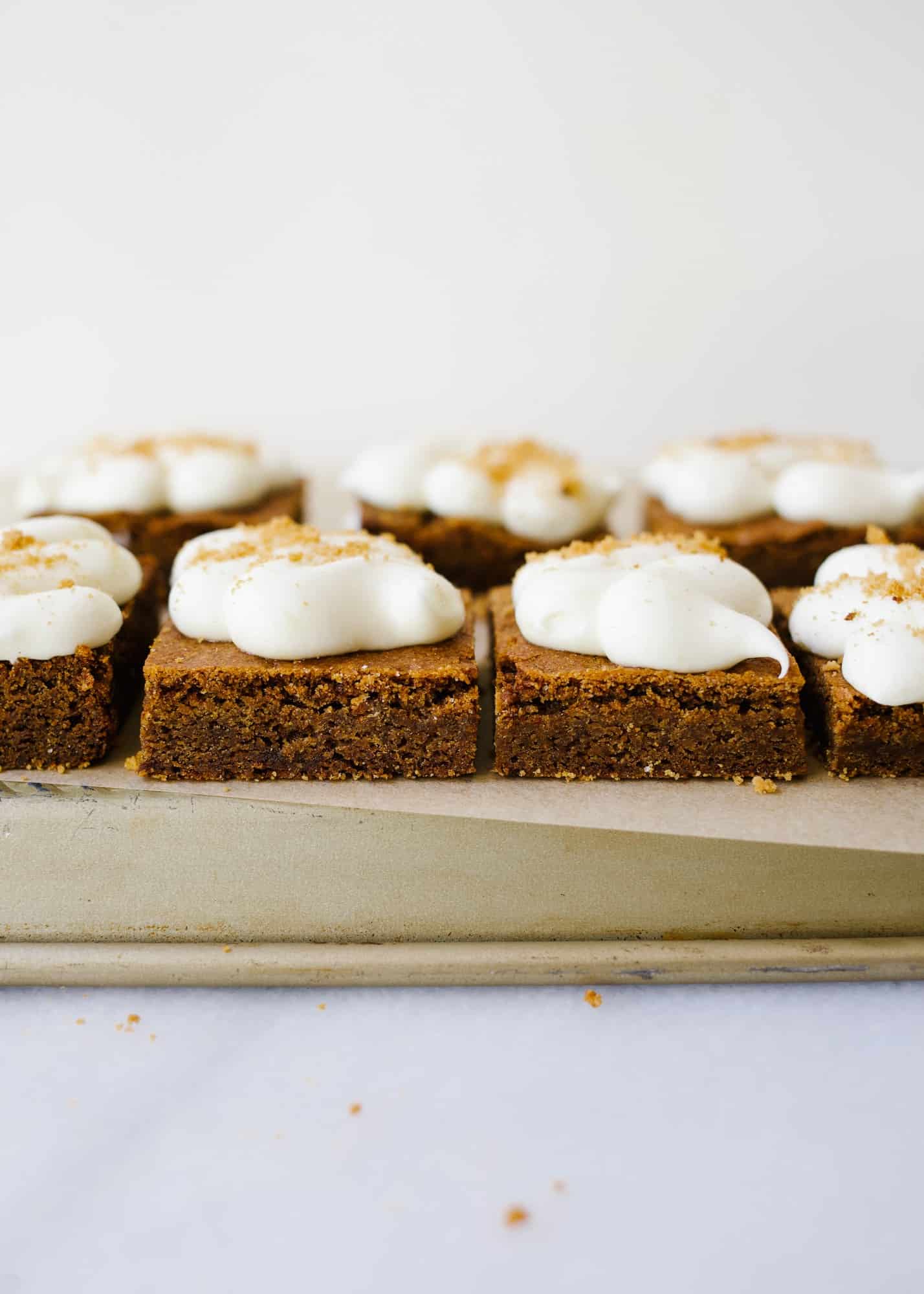 Chewy Gingerbread Lemon Bars by Wood and Spoon. These are soft blondie-like bars flavored with ginger and topped with a cream cheese and lemon frosting! These bars and sweetened and chewy, perfect for the holidays! Learn how to make these sweet gingerbread treats on thewoodandspoon.com